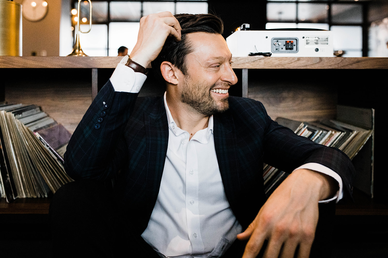 David Blutenthal, founder of Blue Bridge Advisors, seated in front of a vinyl record collection